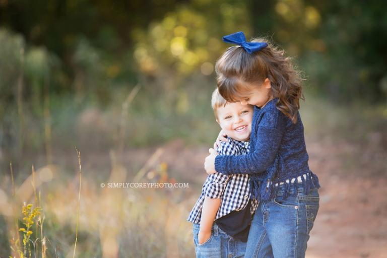 Outdoor photo of siblings hugging by Atlanta family photographer