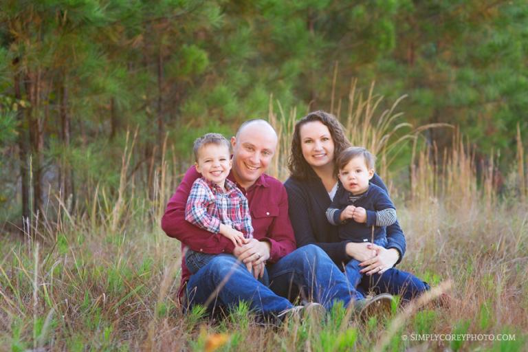 family of four in tall grass by Carrollton family photographer