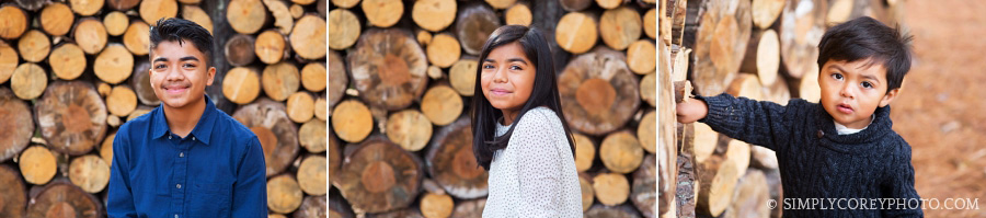 siblings in front of a log pile by Douglasville child photographer