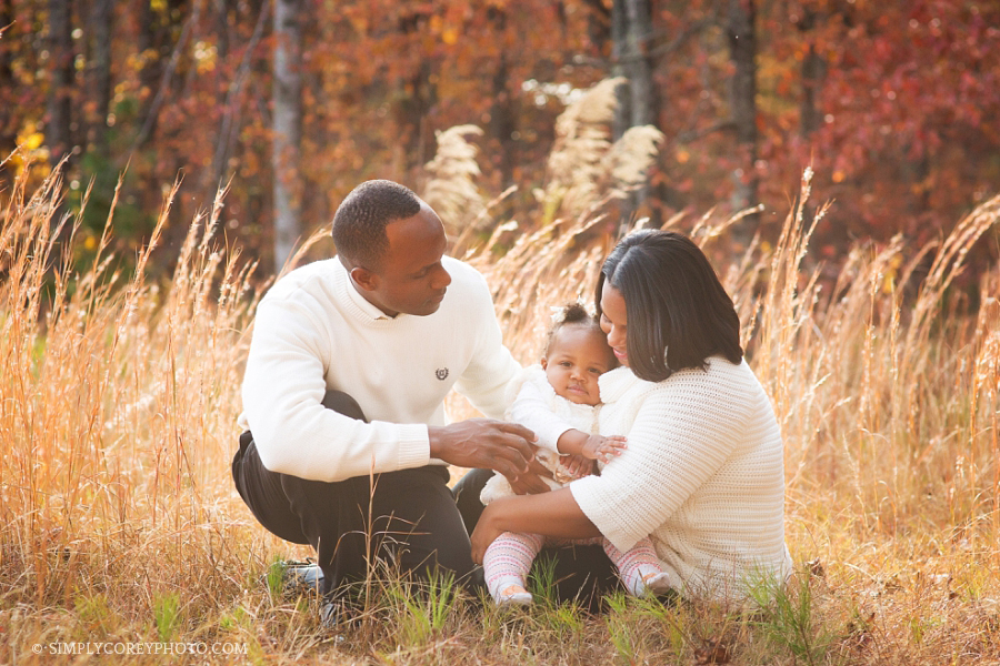 Douglasville family photographer, parents with a baby in a field