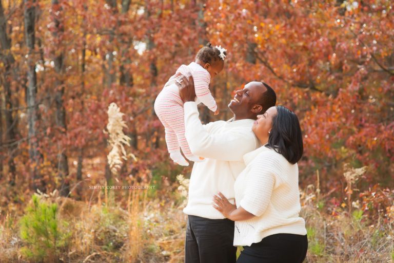 parents playing with their baby girl in an outdoor photo session by Douglasville family photographer