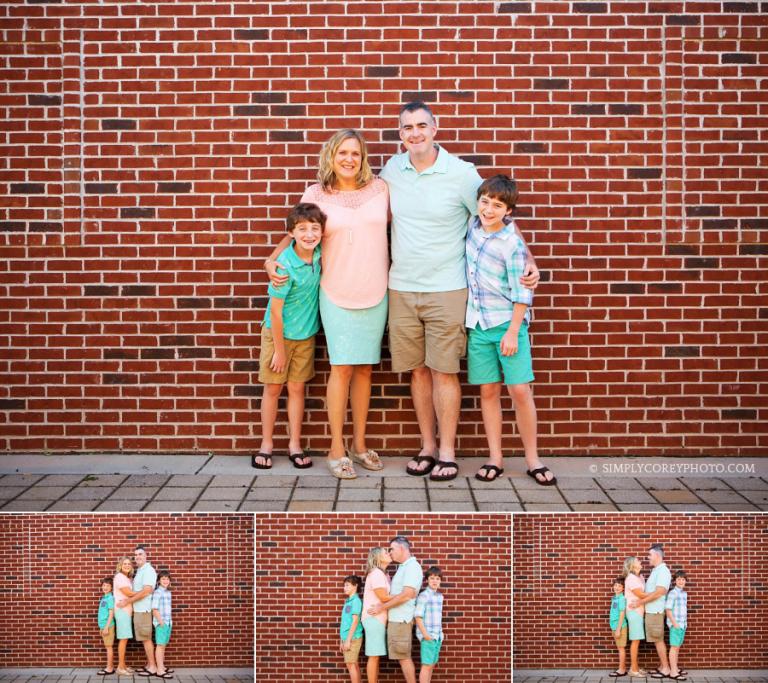 a family of four by a brick wall by Douglasville family photographer