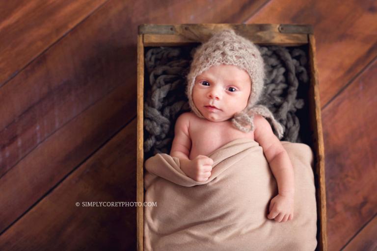 Atlanta newborn photography of a baby boy in a wood prop