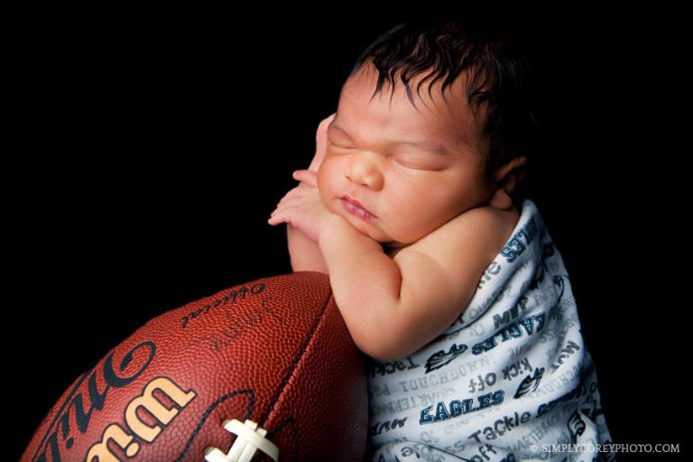 Carrollton newborn photography of a baby boy in an Eagles football blanket 