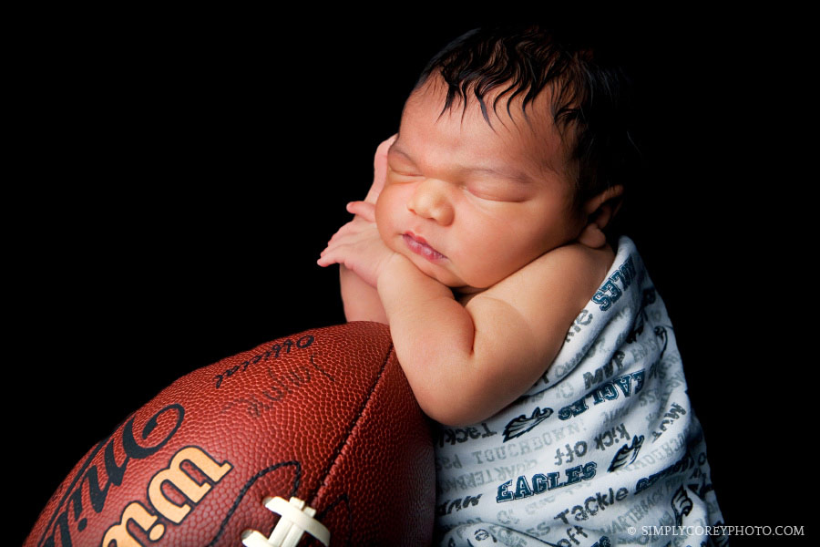 Carrollton newborn photography of a baby boy in an Eagles football blanket 