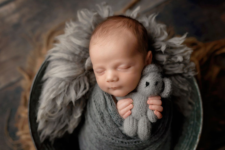 newborn photographer near Dallas, GA; baby boy in gray studio set with bear