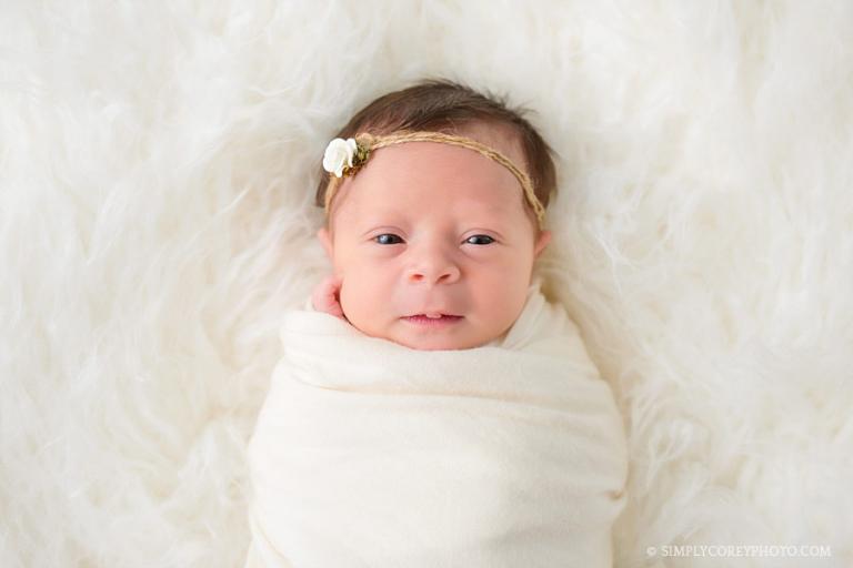 Atlanta newborn photographer, awake baby girl on cream fur