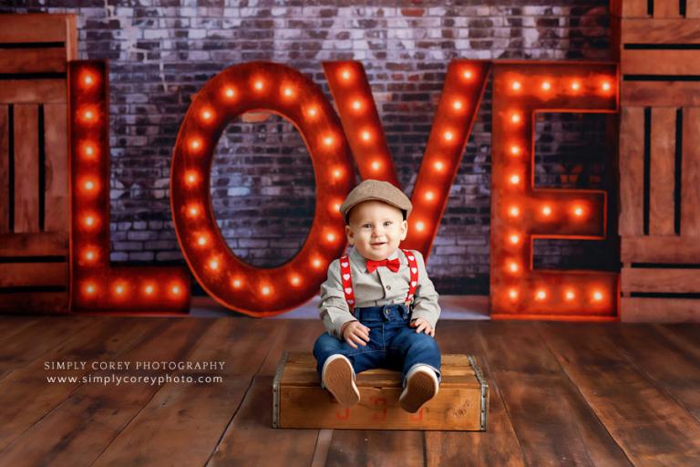 Atlanta baby photographer, marquee love sign with baby in suspenders