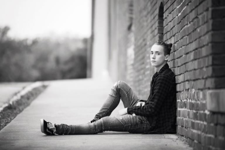 Douglasville senior portrait photography, teen boy by a brick wall downtown