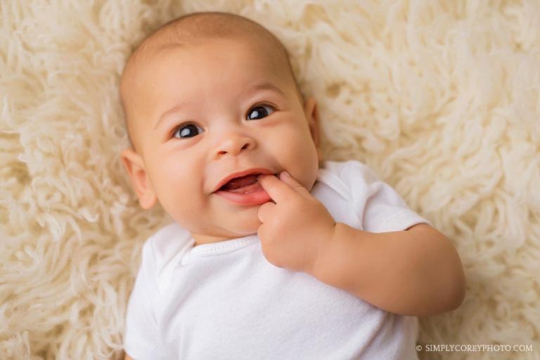 Newnan baby photographer, baby boy smiling with finger in mouth