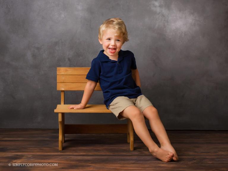 Atlanta studio photographer, child smiling on a bench