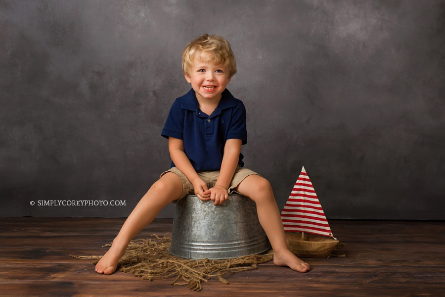 Villa Rica children's photographer, boy with a boat in studio