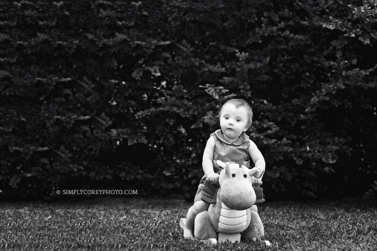Villa Rica baby photographer, one year old outside on a rocking dragon