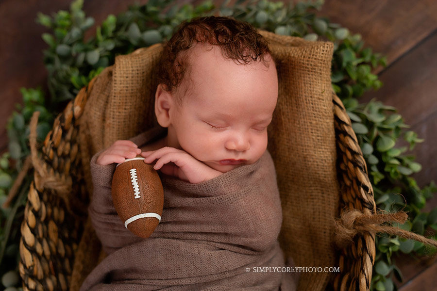 newborn photographer Douglasville, baby boy holding a football
