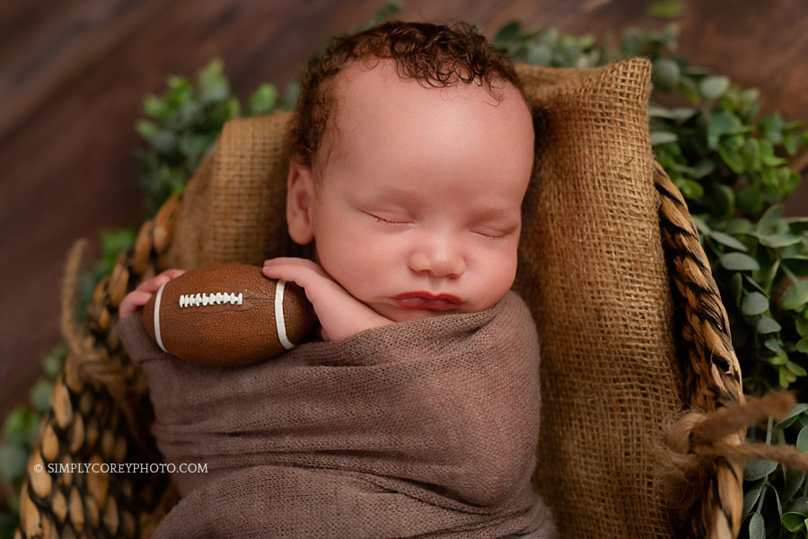 Villa Rica newborn photographer, baby boy in a basket with a football