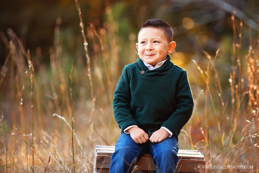 Atlanta children's photographer, boy on a crate in tall grass