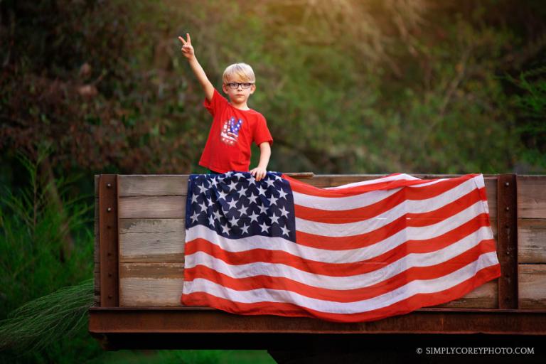 Atlanta photographer, child giving a peace sign with an American flag