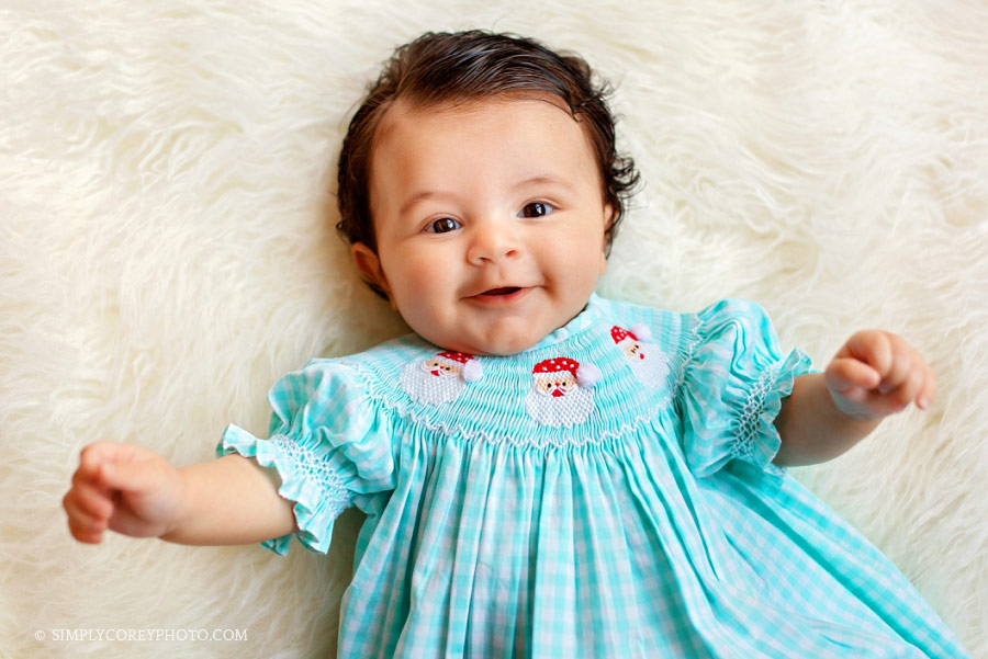 Carrollton baby photographer, girl in Santa Claus smocked dress