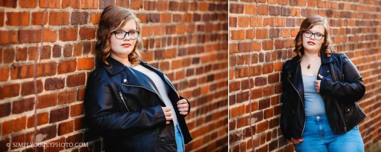 Carrollton senior photographer, teen girl in leather jacket by a brick wall