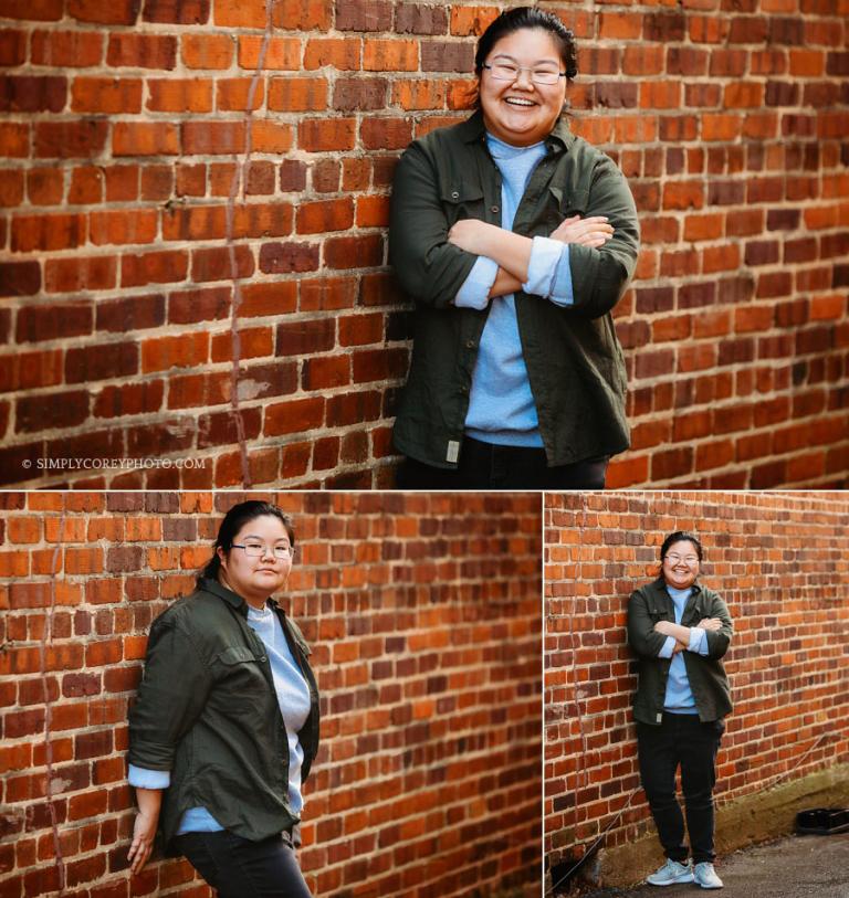 senior portrait photographer near Newnan, teen girl in glasses by brick wall