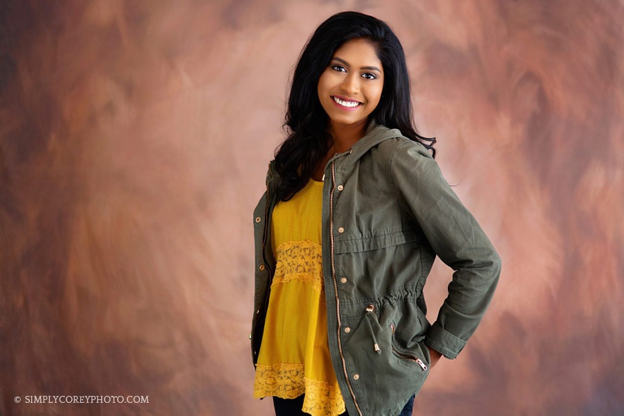 Douglasville senior portrait photographer, teen wearing a green jacket in studio