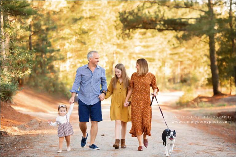 family photographer near Carrollton, GA; walking on a dirt road with dog