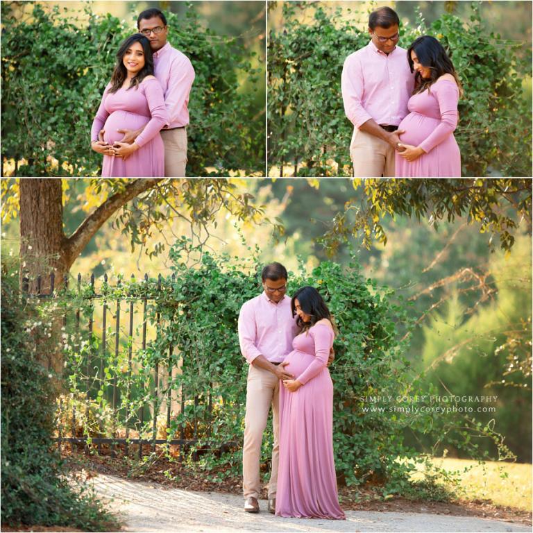 Villa Rica maternity photographer, couple in pink outside by a gate with greenery