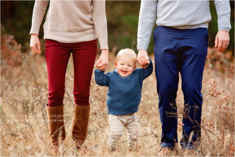 Atlanta family photographer, parents holding baby hands in field