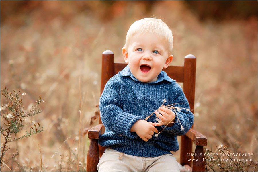 Villa Rica baby photographer, toddler in chair outside for fall mini