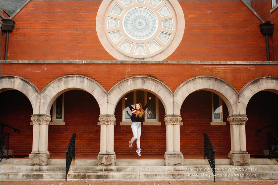 senior portrait photographer near Carrollton, Georgia; teen jumping under arches