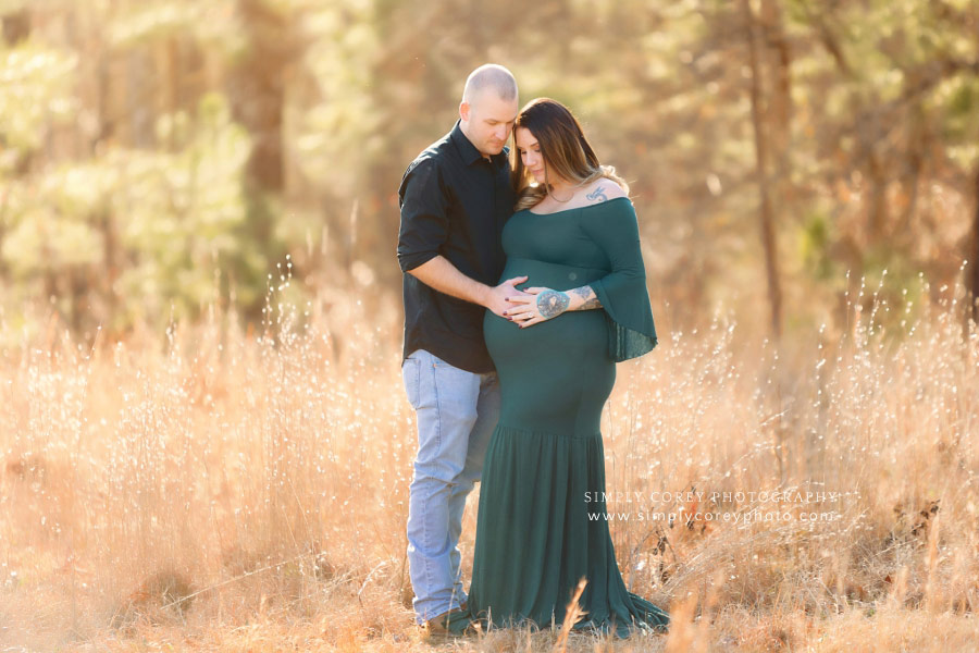 Douglasville maternity photographer, couple outside looking at belly