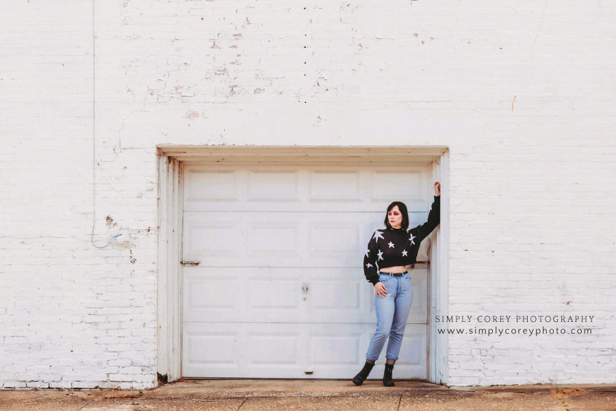 Carrollton photographer, girl in star sweater by white brick wall