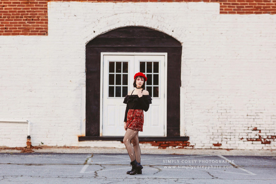 Newnan photographer, girl in red downtown by white brick wall