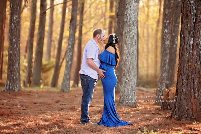Villa Rica maternity photographer, couple kissing outside by pine trees