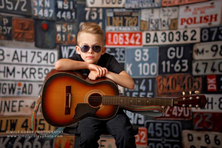 Atlanta photographer, child in sunglasses with guitar on license plate backdrop