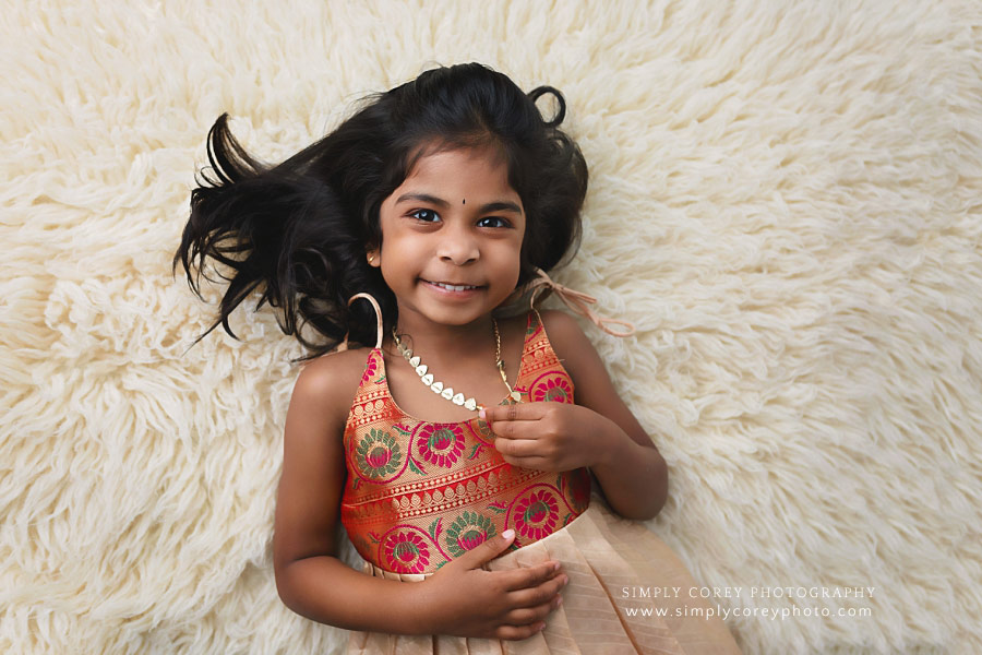 West Georgia children's photographer, girl smiling on flokati fur