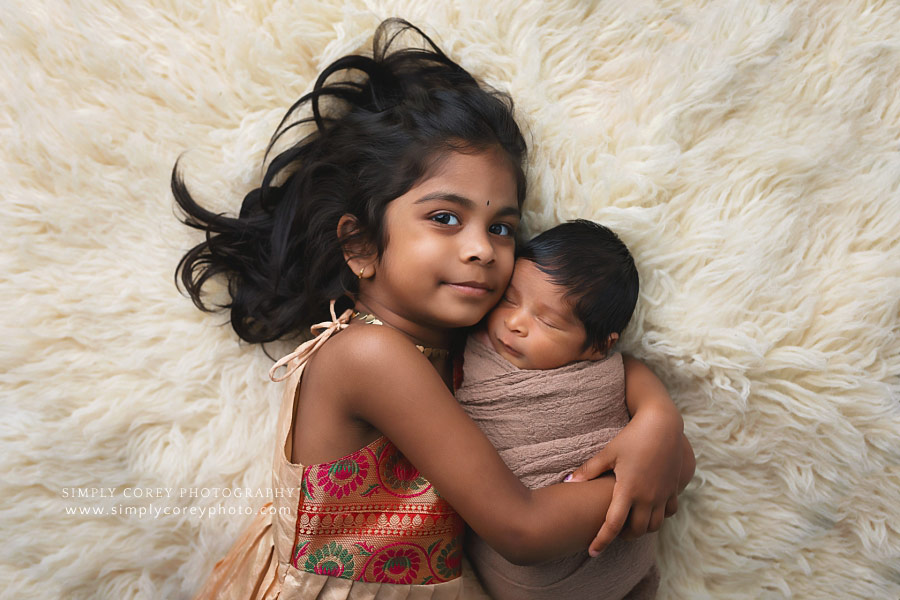 newborn photographer near Atlanta, sister cuddling baby brother