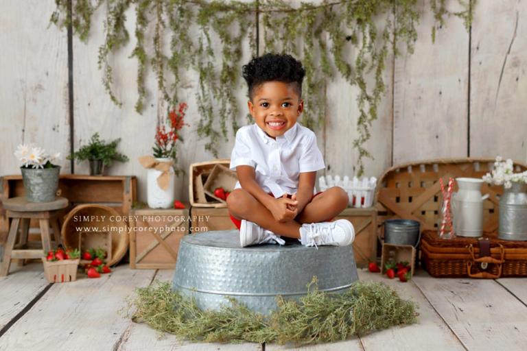 Villa Rica children's photographer, child on bucket for studio mini session in summer