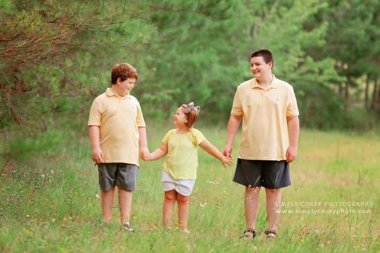 Atlanta family photographer, kids holding hands in a field