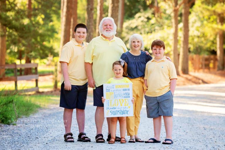 Douglasville family photographer, grandparents and grandkids outside with sunshine sign