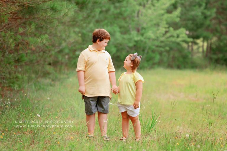 Newnan family photographer, kids holding hands for sibling portrait