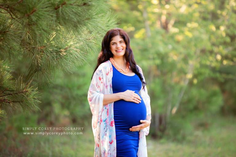 maternity photographer near Atlanta, pregnant mom in blue outside by pine trees
