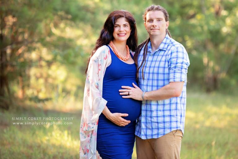 Peachtree City maternity photographer, couple in blue outside in a field