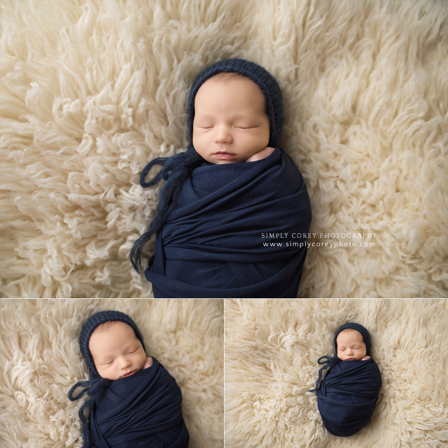 Bremen newborn photographer, baby boy in navy blue wrap and hat on a flokati