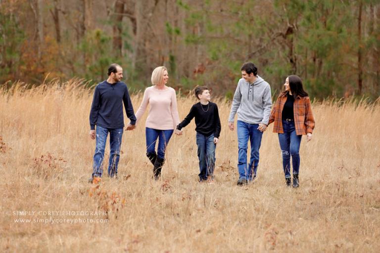 family photographer near Carrollton, Georgia; walking in a field with tall grass