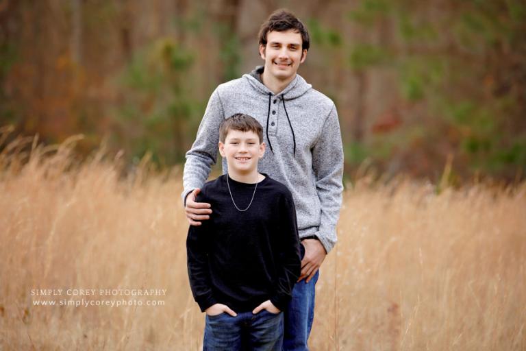 family photographer near Newnan, brothers outside in a field with tall grass