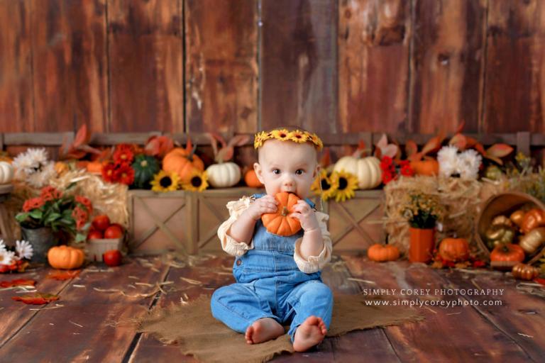 baby photographer near Carrollton, Georgia; girl holding pumpkin with fall theme