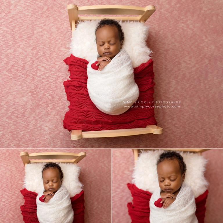 West Georgia newborn photographer, baby boy holding heart on a bed