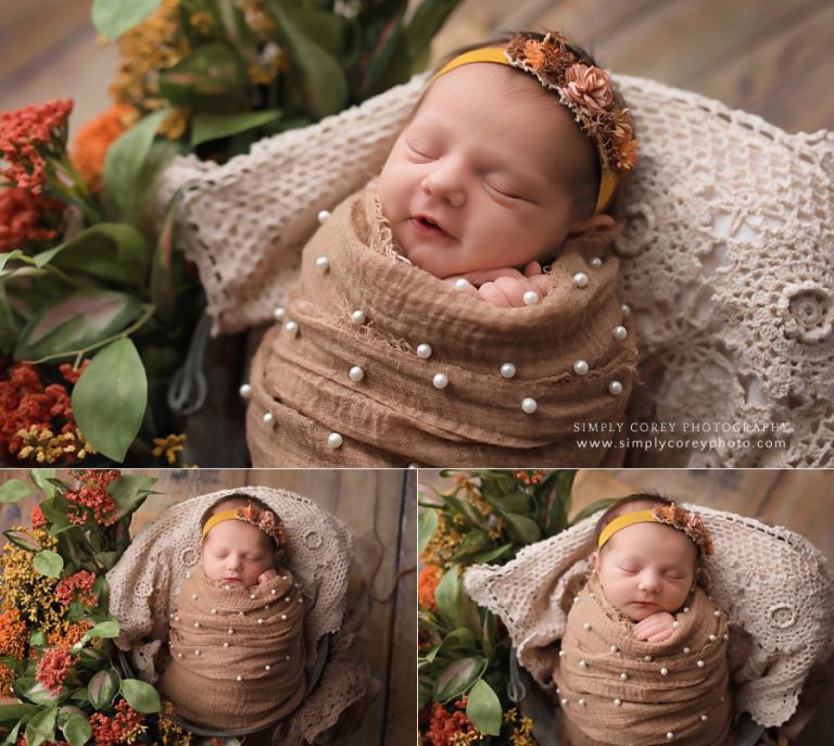 newborn photographer near Newnan, GA; baby girl smiling in brown pearl wrap