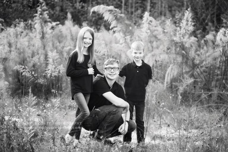 Peachtree City family photographer, kids outside in field with tall grass